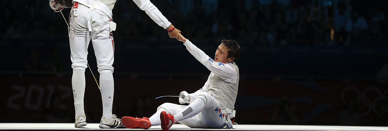 A fencer helping a competitor to their feet